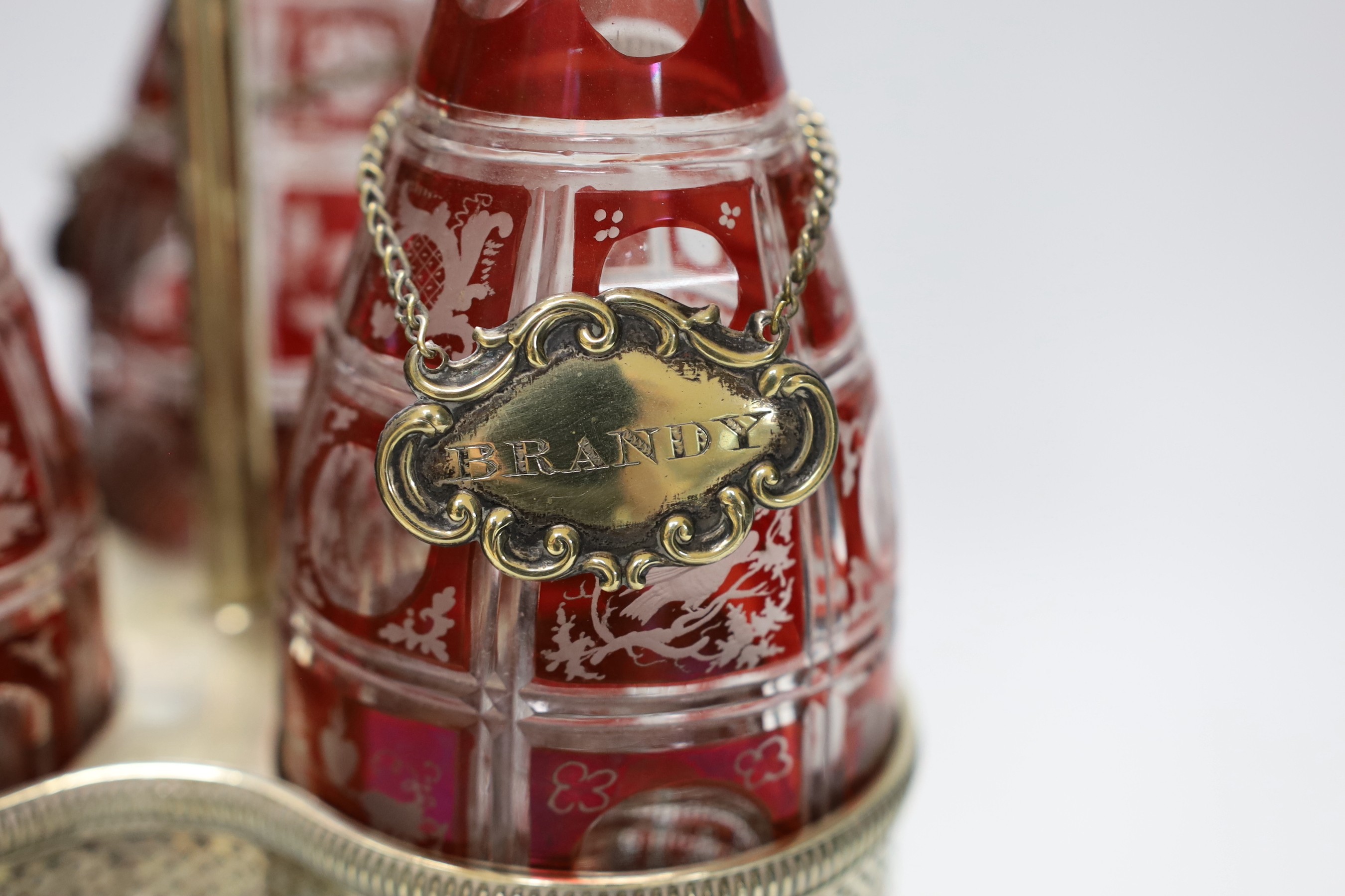 A Victorian three bottle ruby flashed glass and electroplate decanter stand, overall 46cms high